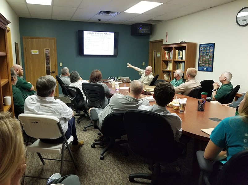 A group of people around a conference table talking