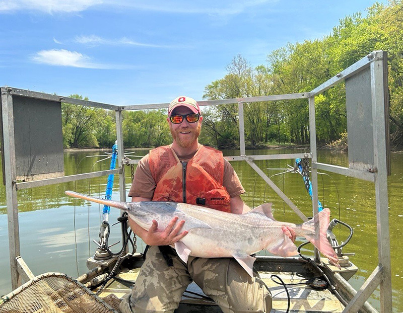 man holding a paddlefish