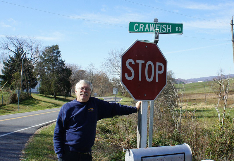 roger thoma leaning on stop sign